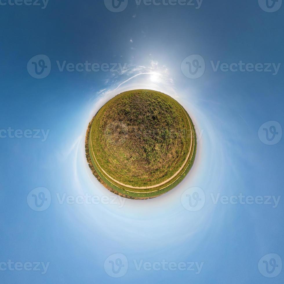 Little planet transformation of spherical panorama 360 degrees. Spherical abstract aerial view in field with awesome beautiful clouds. Curvature of space. photo