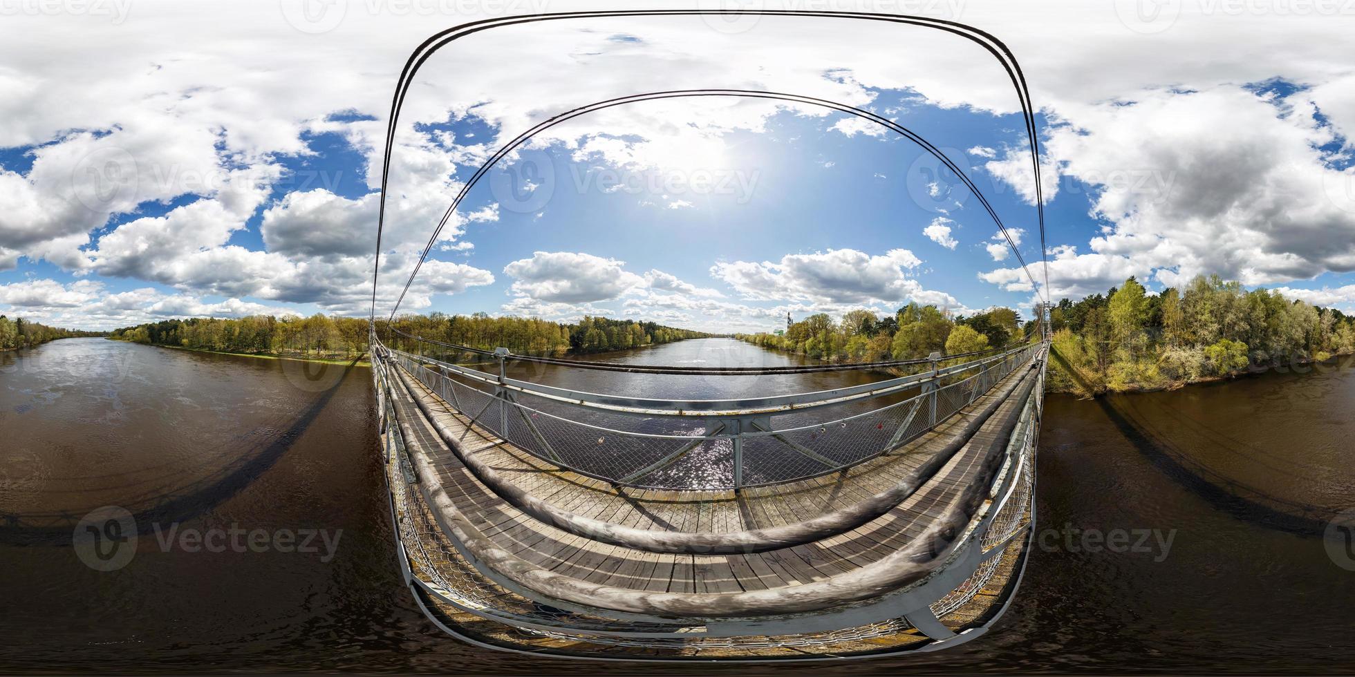 Aerial full seamless spherical 360 angle degrees view panorama from pedestrian suspension wooden bridge above wide river in sunny day in equirectangular projection. skybox for VR AR content photo