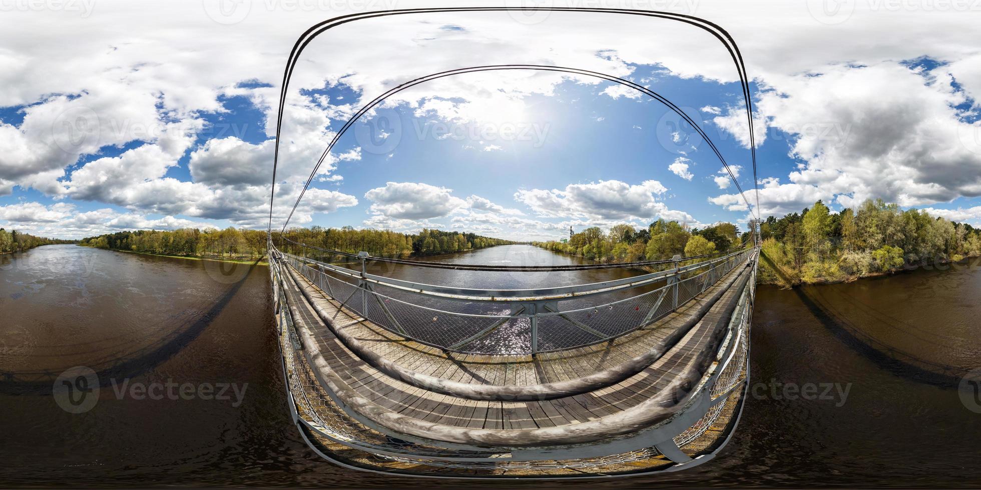 Aerial full seamless spherical 360 angle degrees view panorama from pedestrian suspension wooden bridge above wide river in sunny day in equirectangular projection. skybox for VR AR content photo