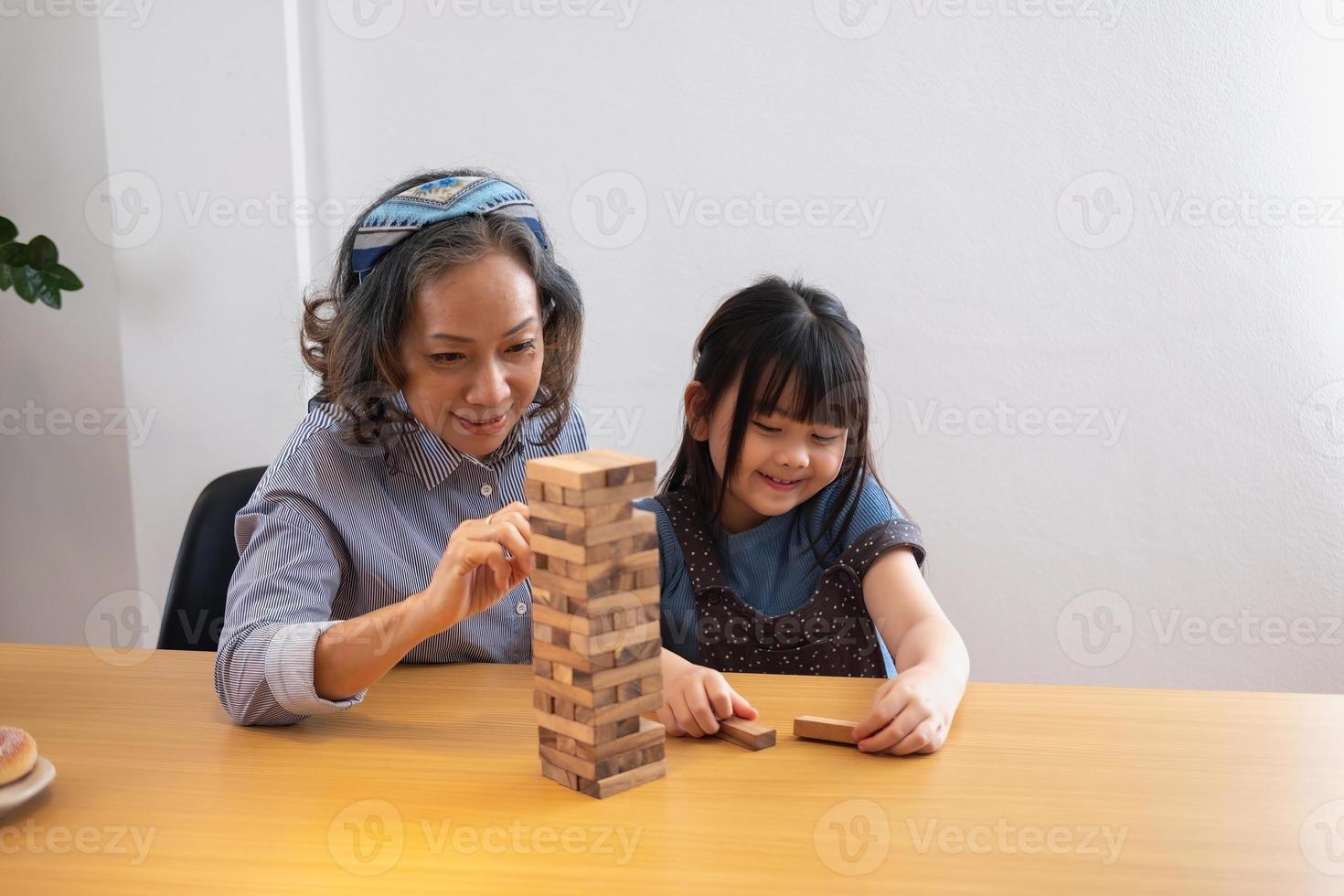 Grandmother and granddaughter play games. Blockwood Puzzle To develop skills for granddaughter and as a holiday activity photo