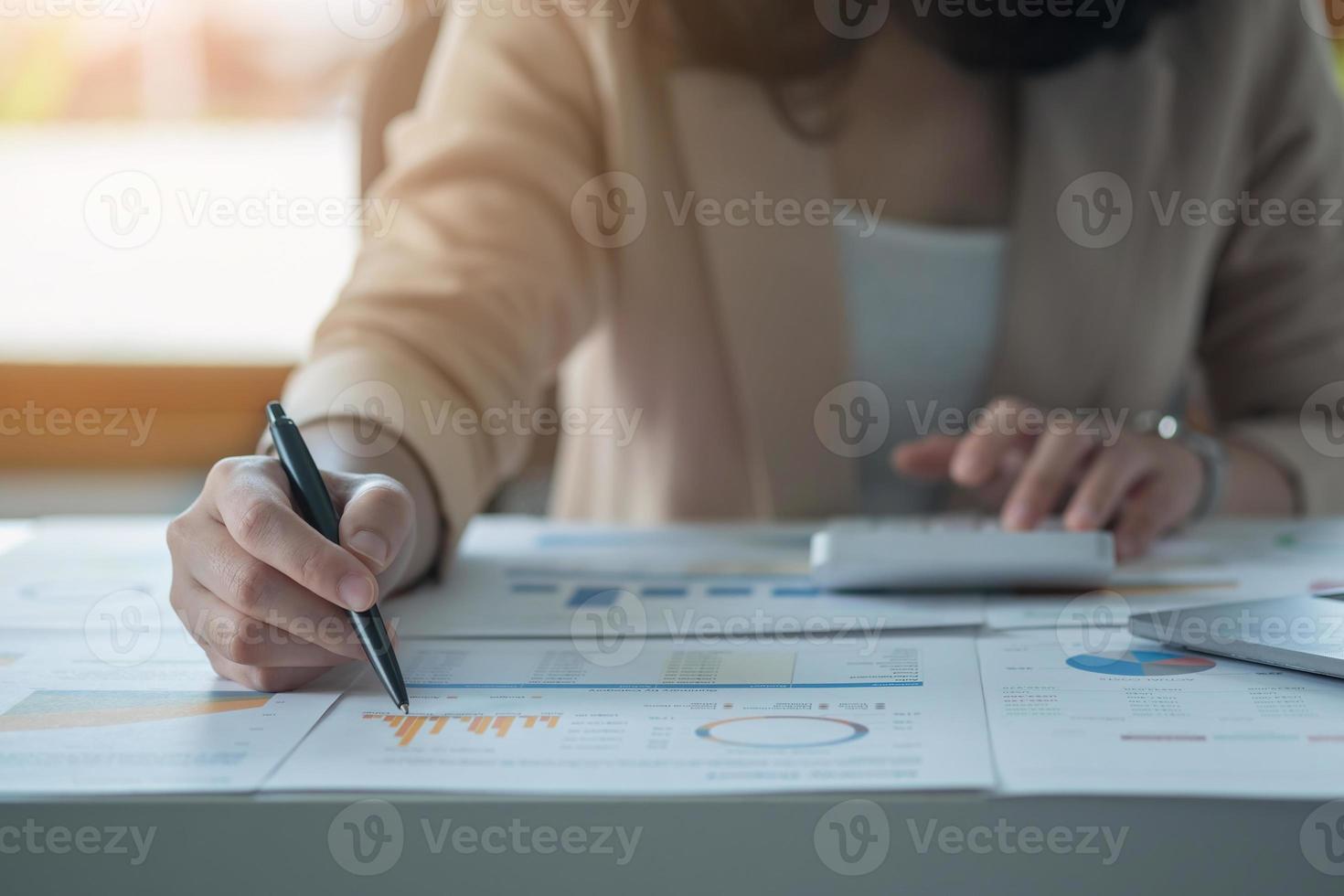 Marketing, Financial, Accounting, Planning, Team of female businessmen and economists use calculators and computers and graph documents to profit the company. photo