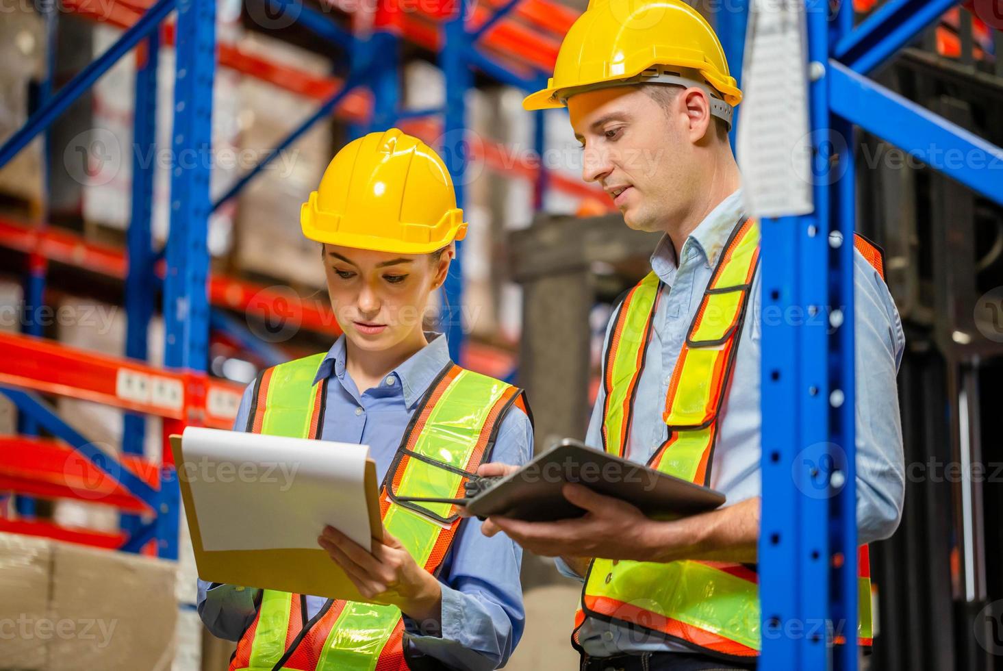 Manager and supervisor taking inventory in warehouse, Female foreperson making plans with warehousemen, Workers working in warehouse photo