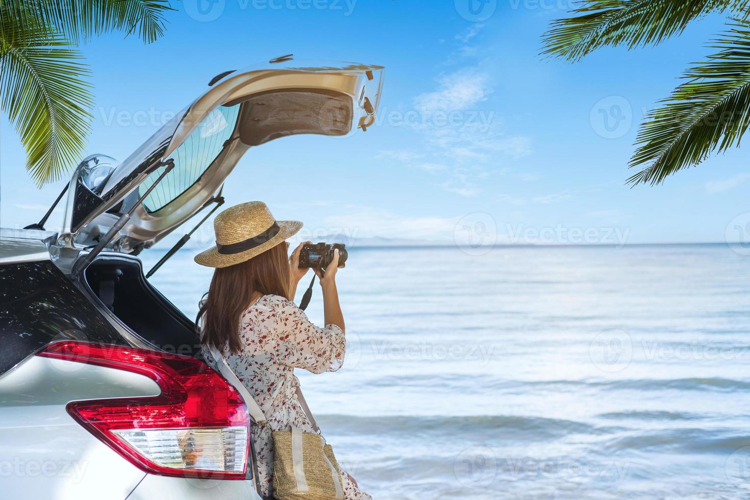 joven viajera tomando una foto en la playa con un auto en un viaje por carretera, vacaciones de verano