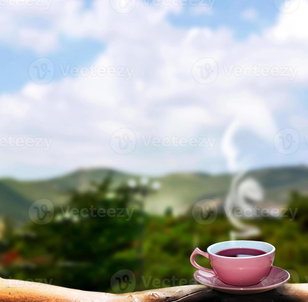 Cup of hot tea on a background summer landscape photo