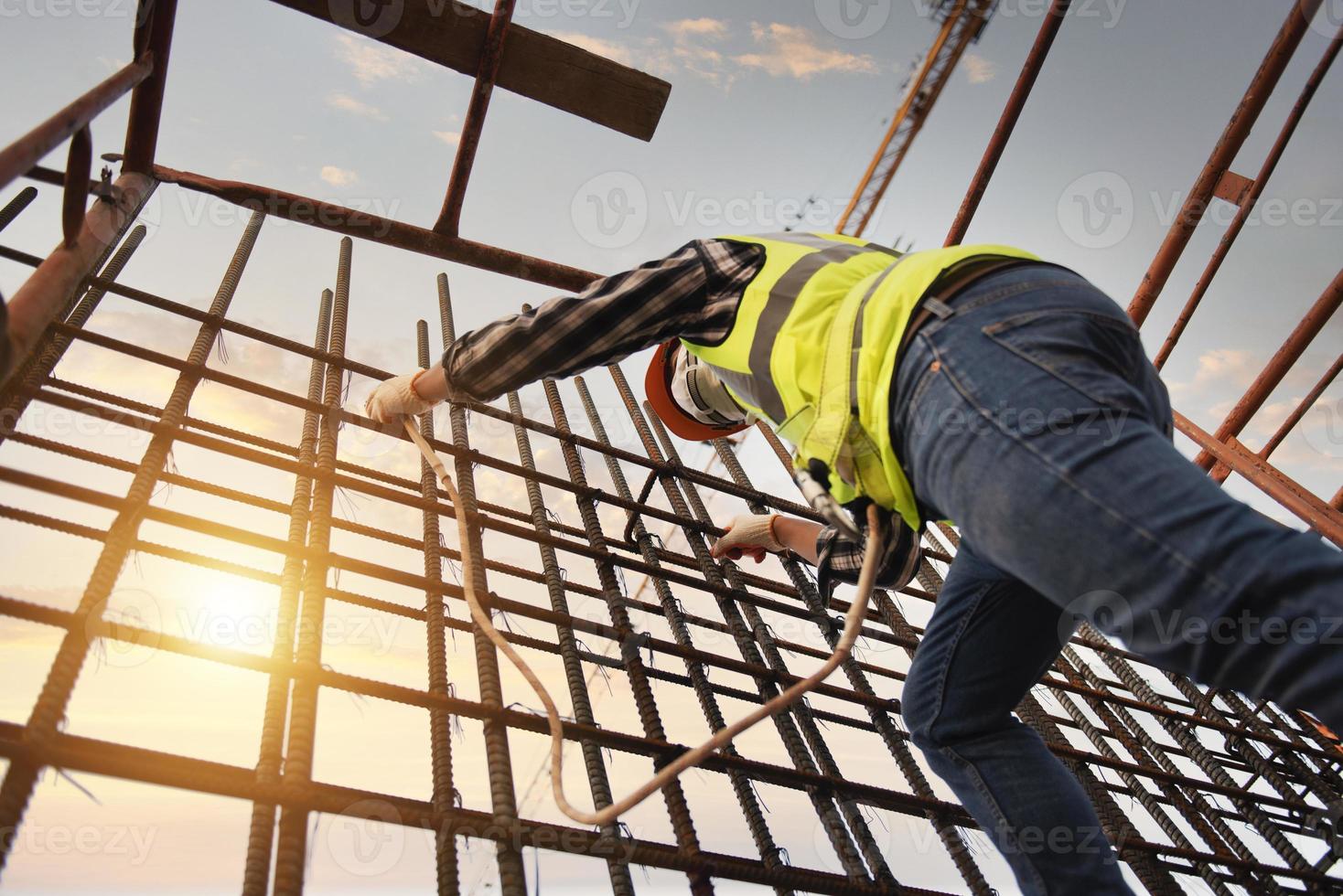 los trabajadores profesionales de la construcción usan arneses de seguridad y cables de seguridad que trabajan en andamios de construcción de hospitales. foto