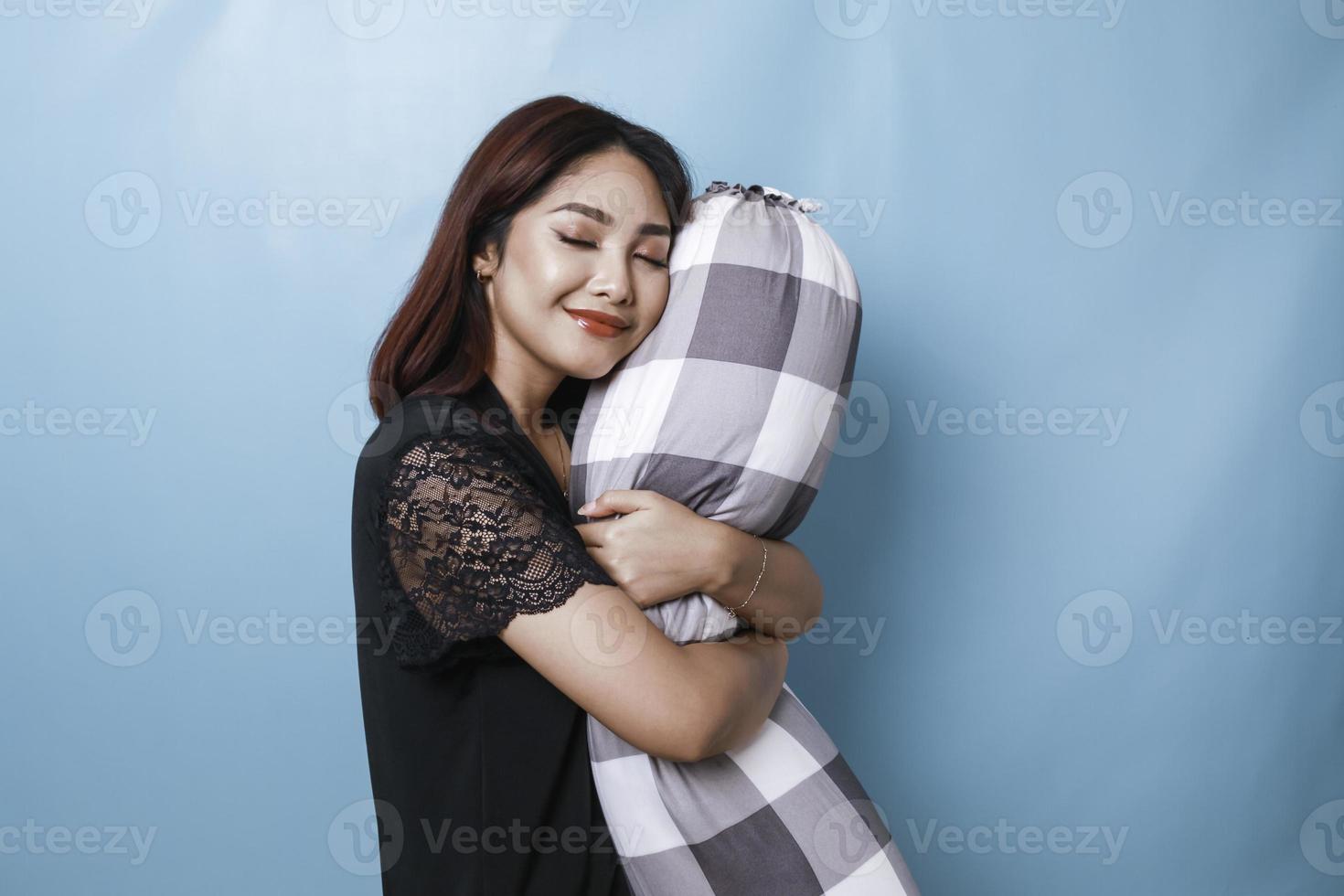 Portrait of sleepy attractive Asian woman wearing pajamas, holding bolster falling asleep photo