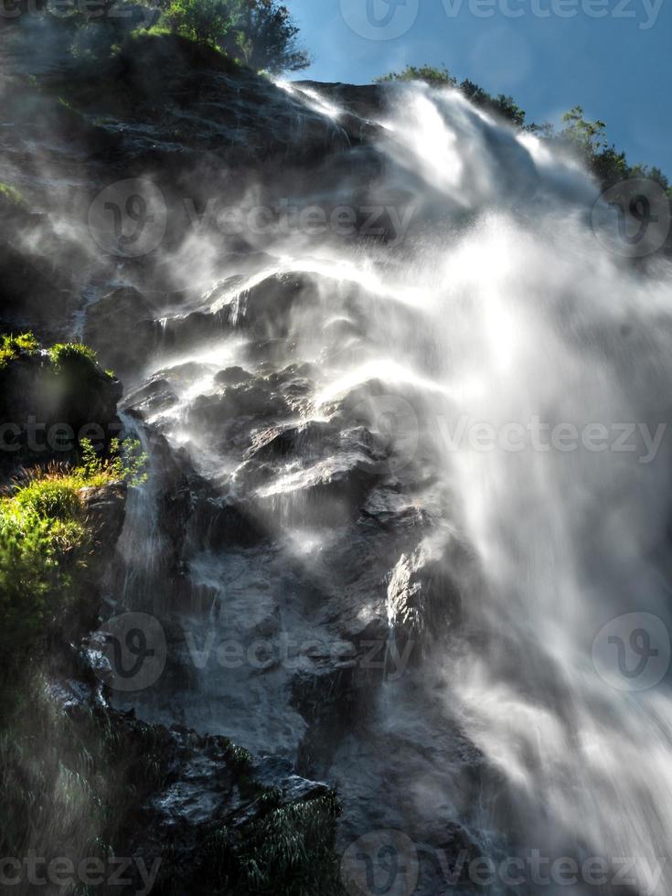 el agua que cae en una cascada crea una nube de polvo de agua. foto