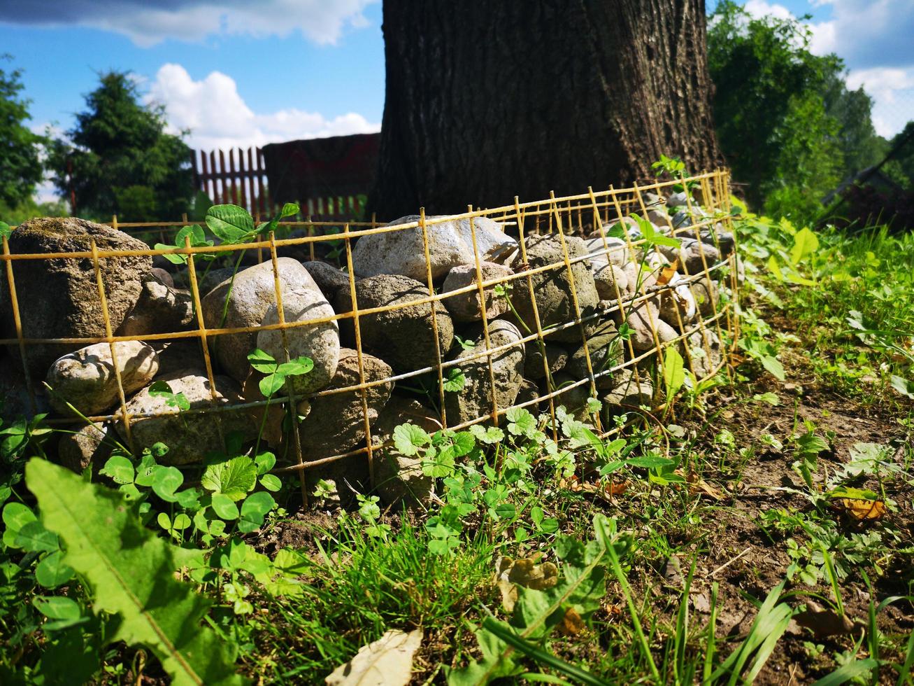 Fence at the flowerbed made of lattice and stones photo