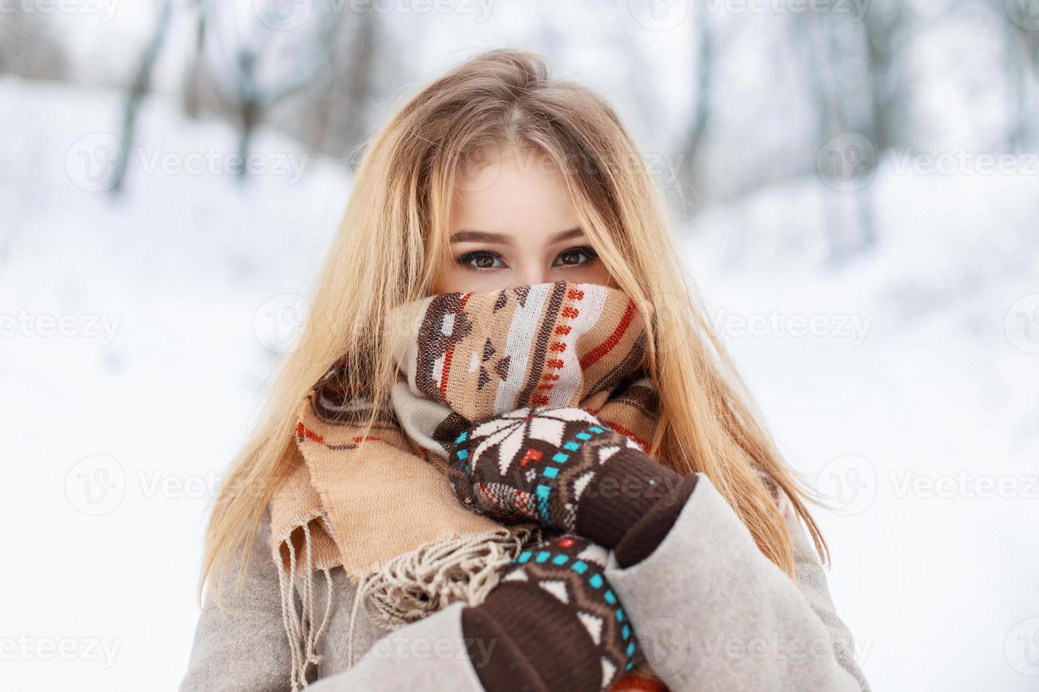 Portrait of a beautiful girl in a scarf and gloves in winter park. Vintage collection. Keep warm photo