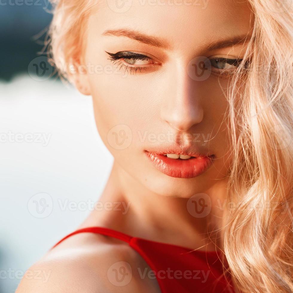 Close-up portrait of young beautiful woman, on blue background summer nature. photo
