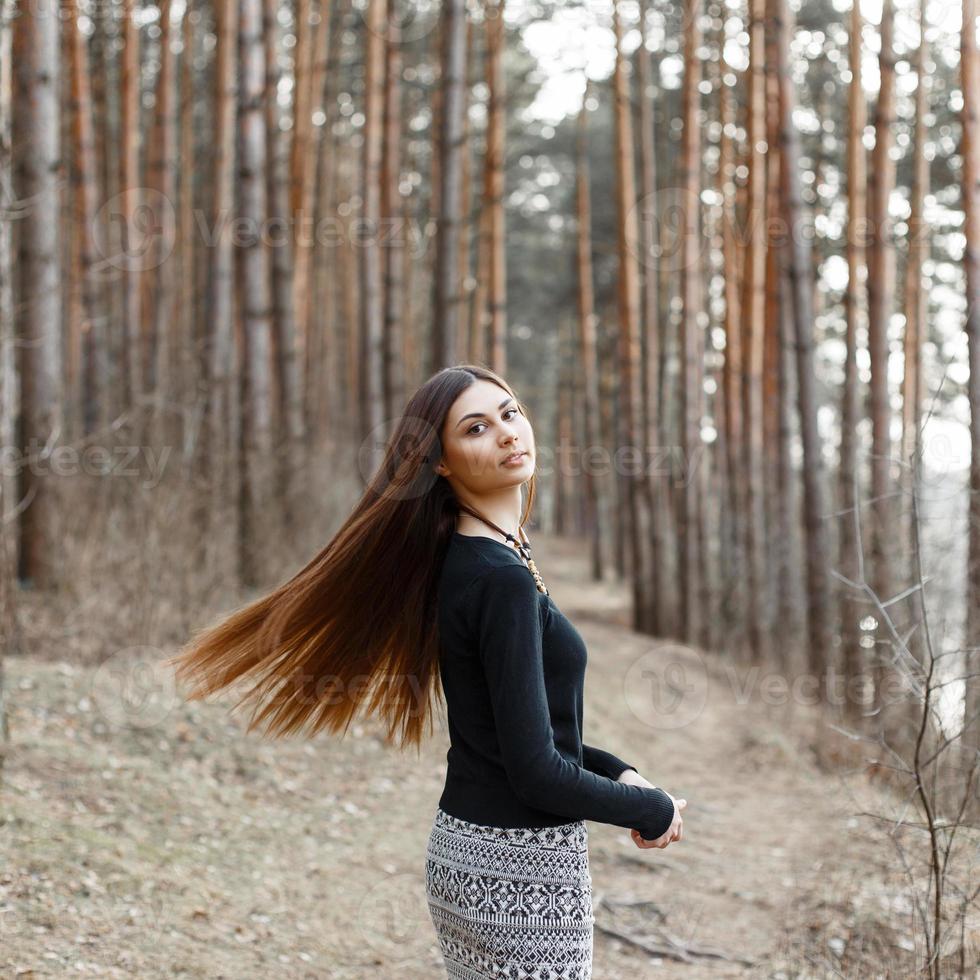 hermosa chica con cabello largo relajándose en el bosque foto