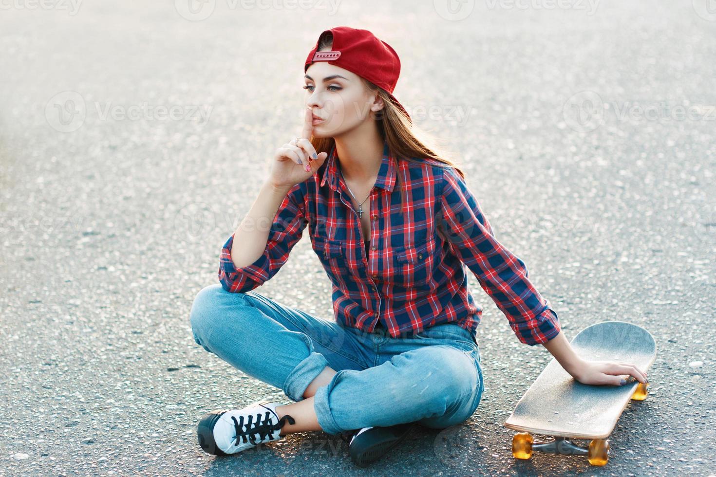 Beautiful and fashion young woman posing with a skateboard photo