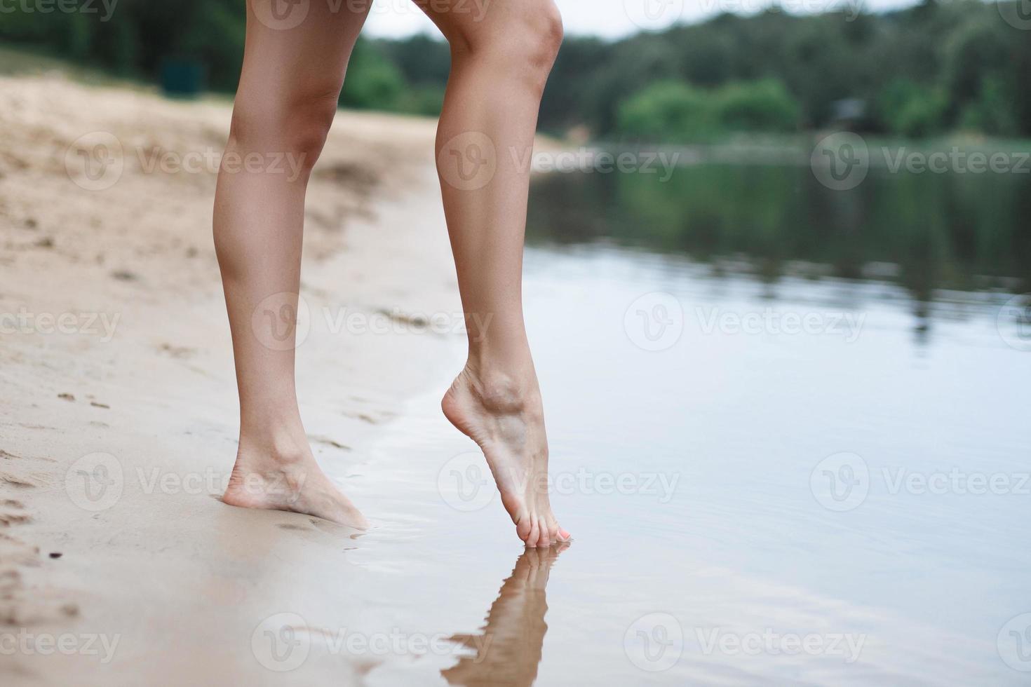 Beautiful female legs go into the water photo