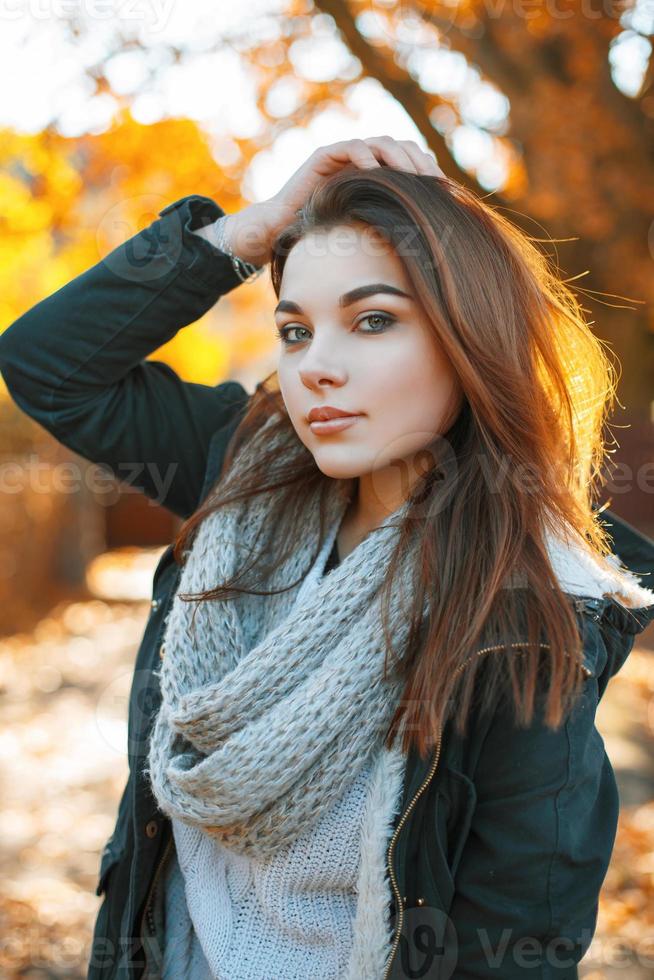 Beautiful girl in a knitted sweater and jacket in the autumn park photo