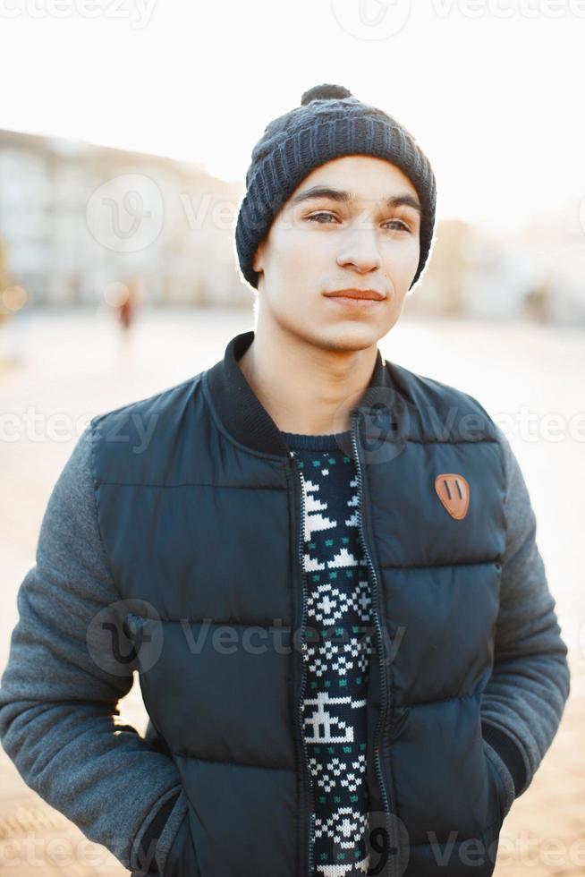 joven apuesto en un día de invierno con ropa abrigada al atardecer foto