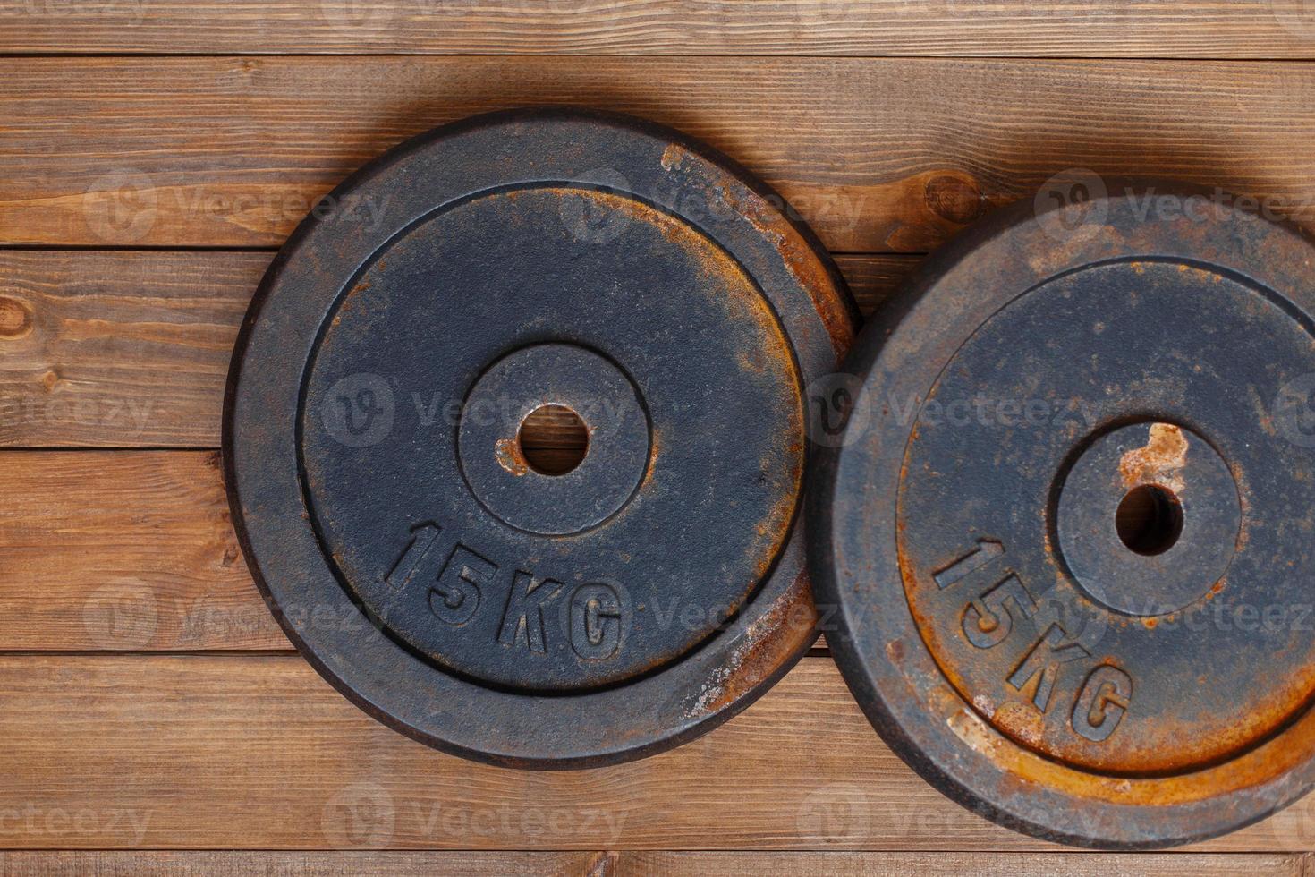 Metal weight with rust for the bench on a wooden background photo