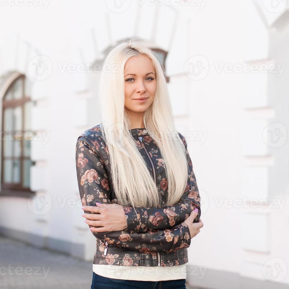 retrato de mujer joven y bonita con pelos rubios. se encuentra cerca de los edificios. foto