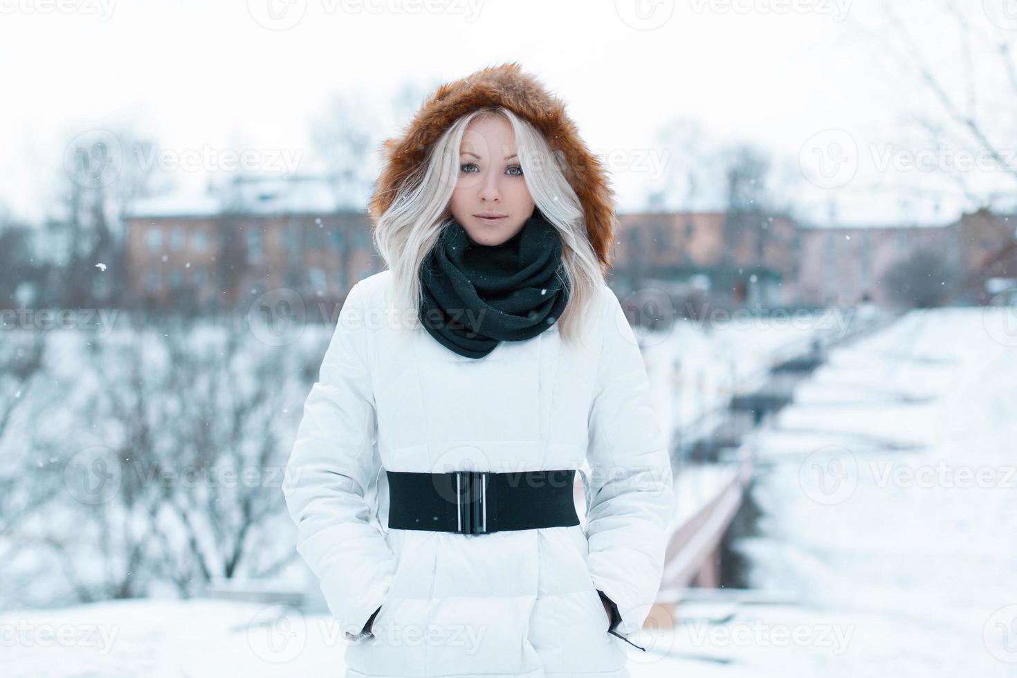 Beautiful girl in a winter jacket in the park photo