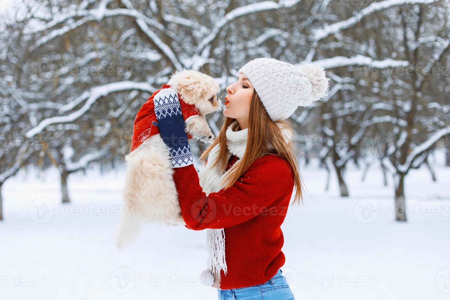 mujer elegante sosteniendo un perro y lo besa foto