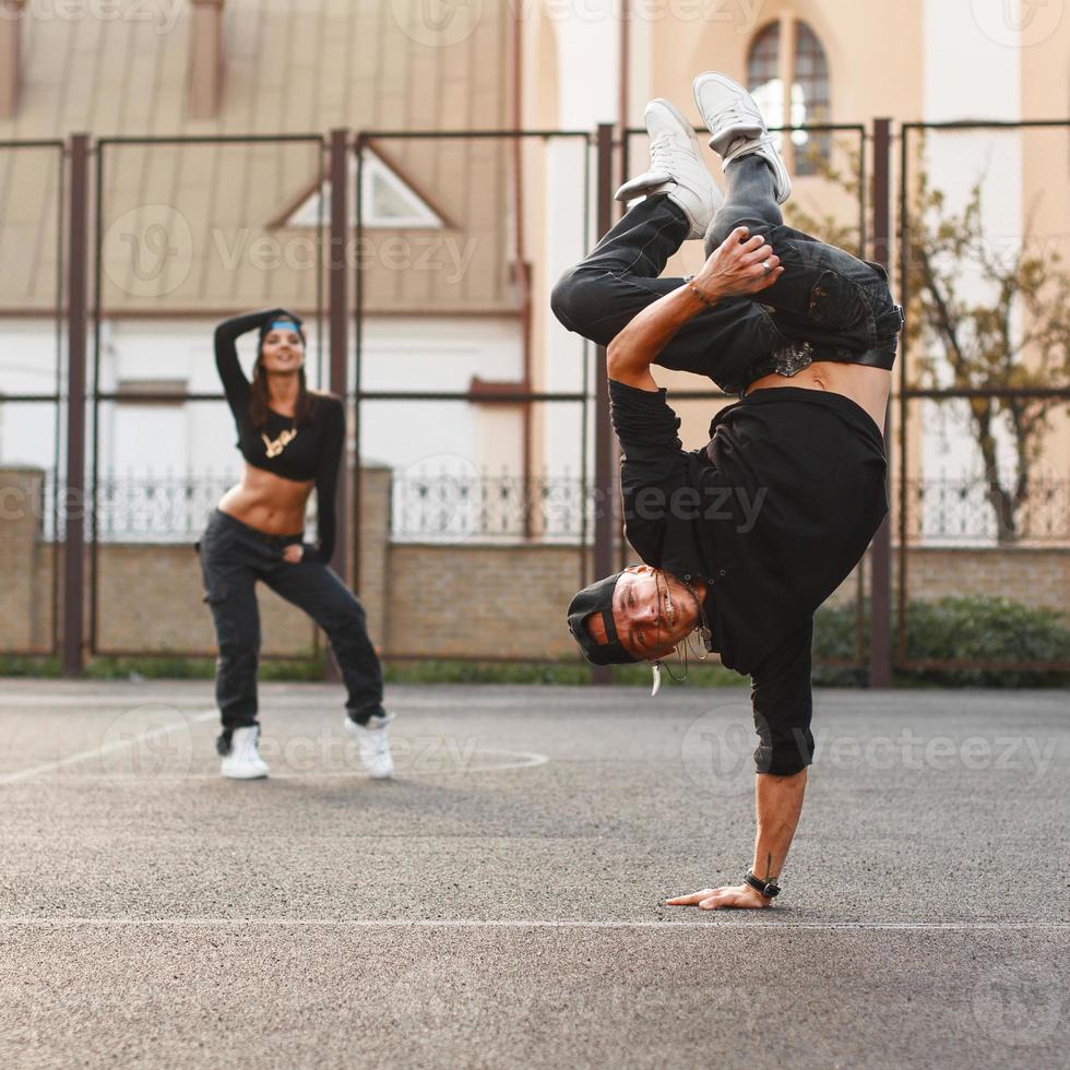 The young dancer standing on his hand. Dancing hip hop with a beautiful girl. photo