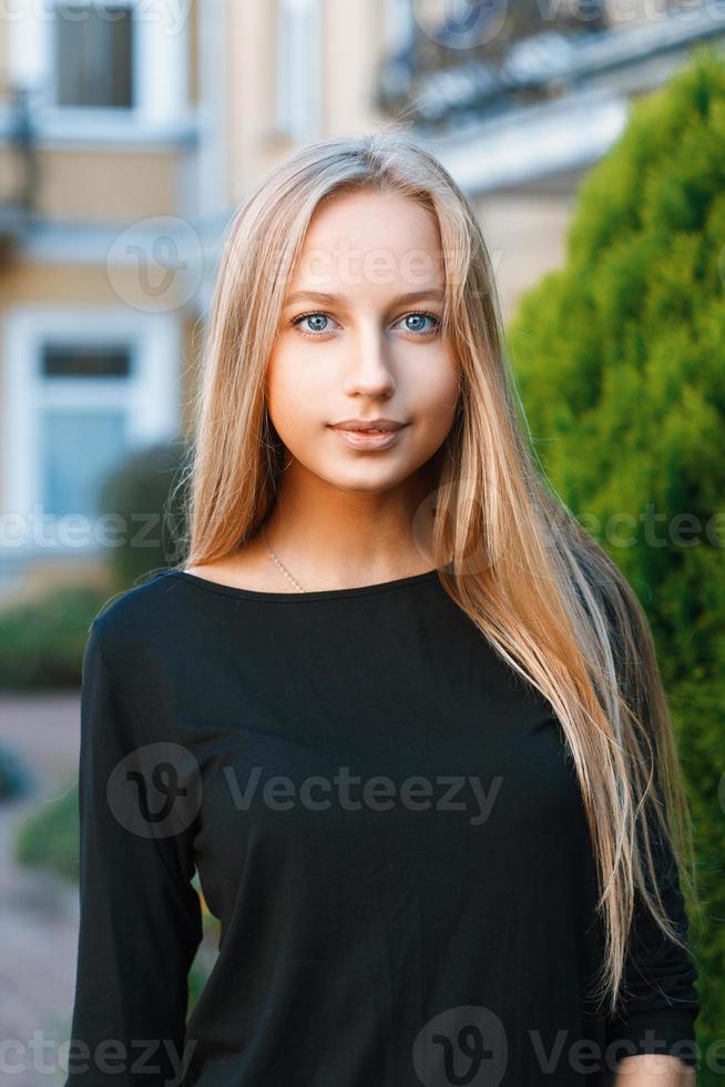 Beautiful blue-eyed girl on the background of houses photo