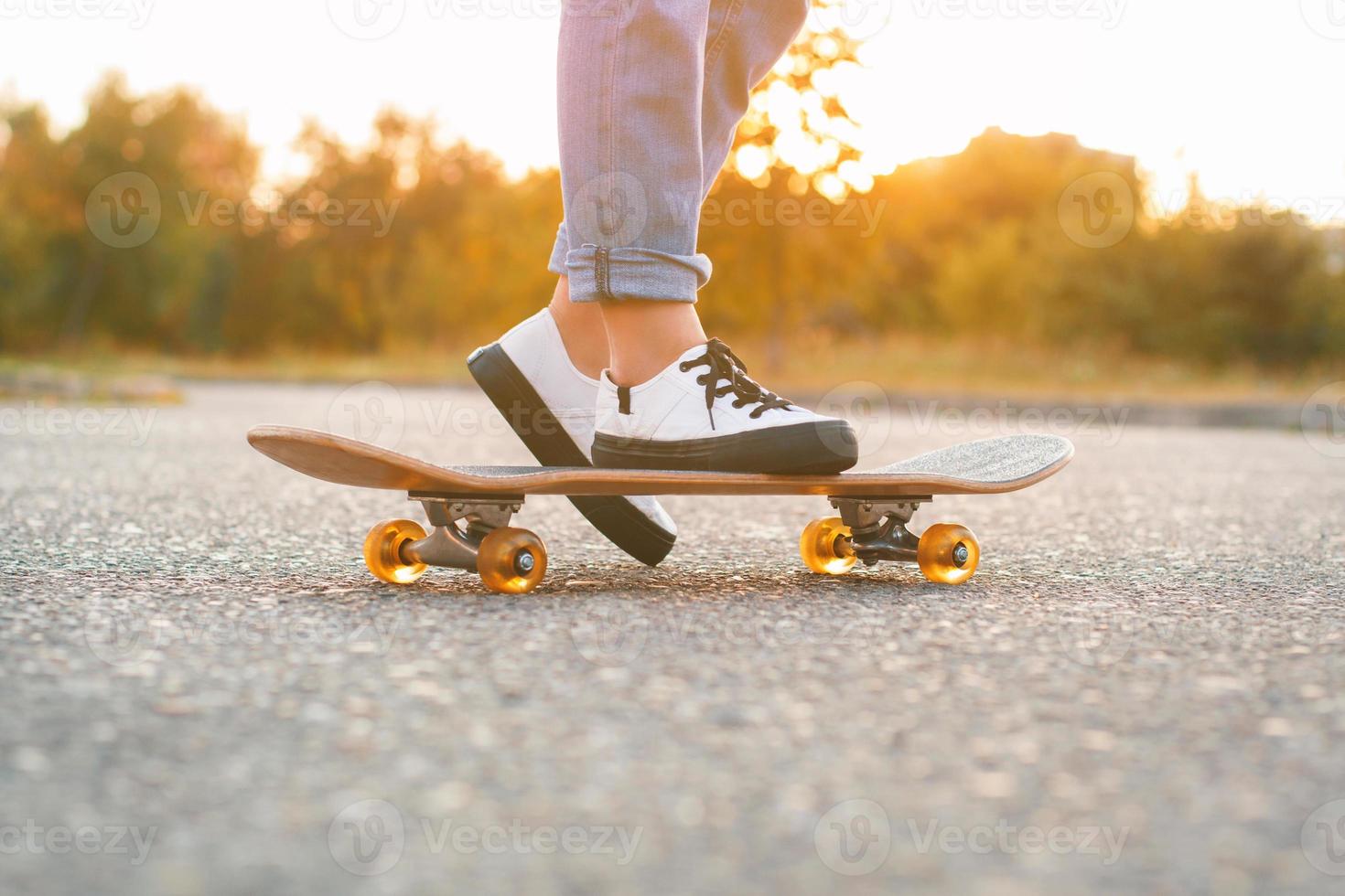 Girl standing on a skateboard. Close up of feet and skateboard. photo