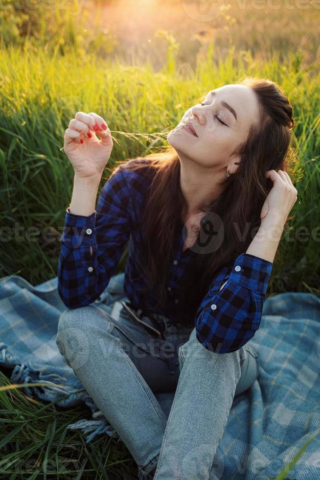Portrait of a beautiful young woman on meadow photo