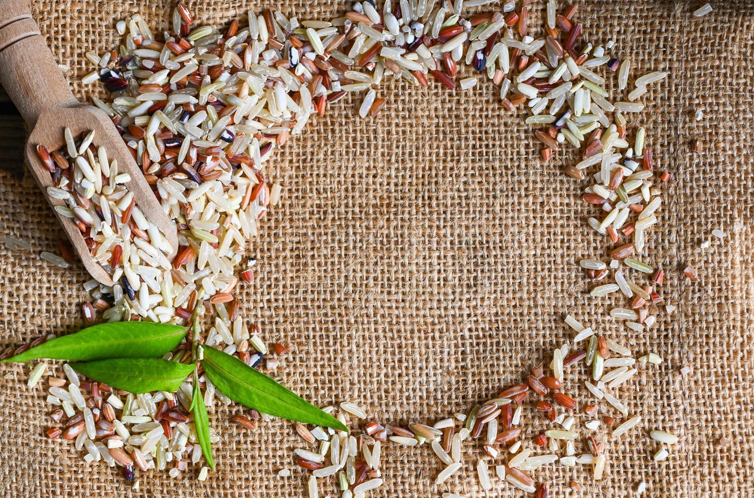 arroz integral en el fondo del saco, varios colores de arroz crudo, arroz tailandés mezclado para cocinar alimentos, arroz loonzain, marrón, negro, rojo, blanco, púrpura, alimentos saludables. foto