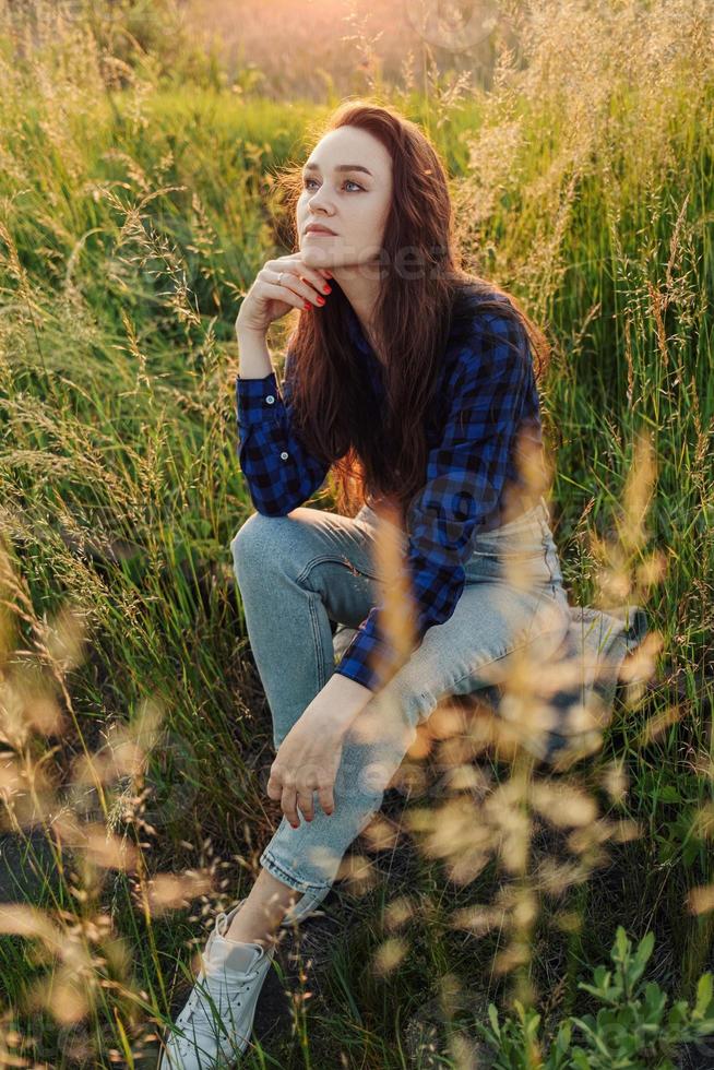 Portrait of a beautiful young woman on meadow photo