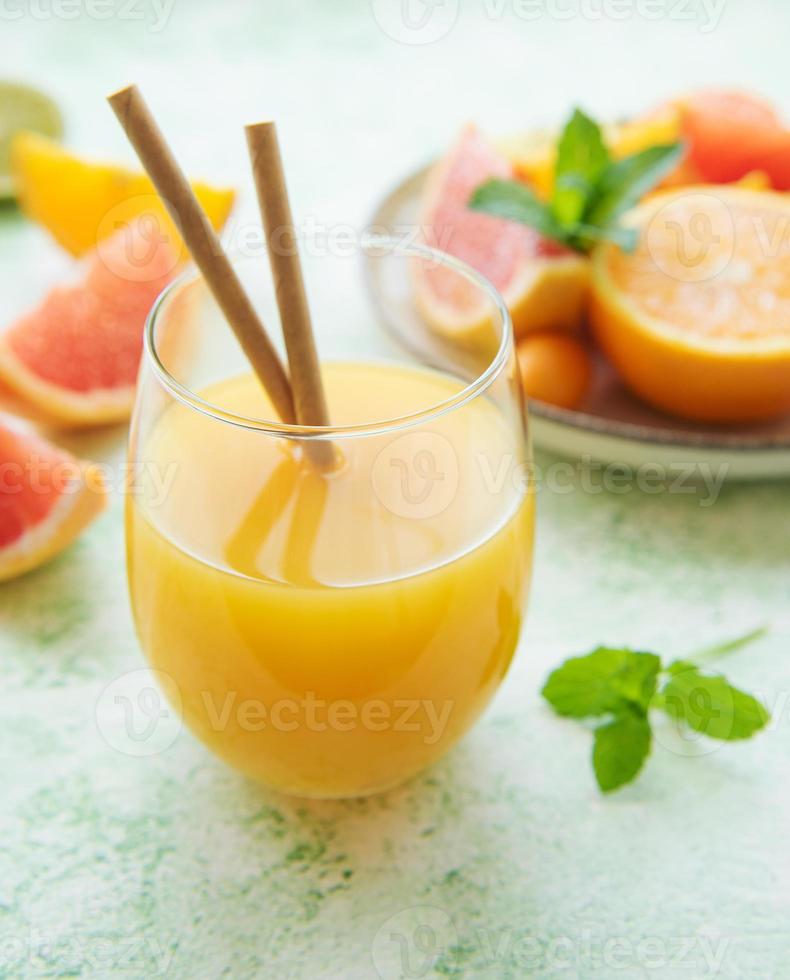 Glass of juice and citrus fruits photo