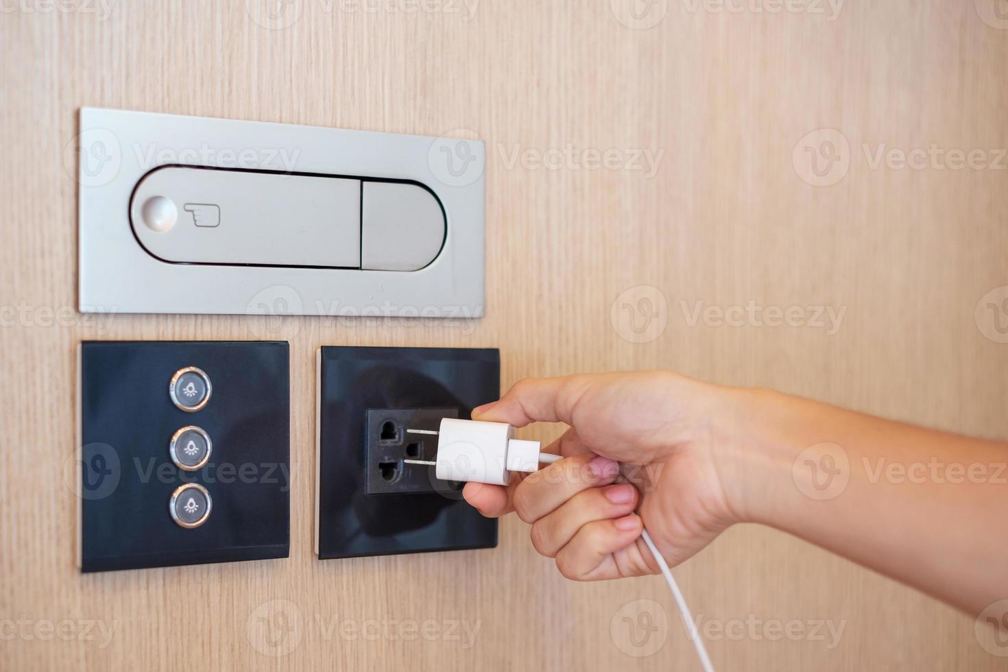 Closeup finger unplugging or plugging of electricity device at home. Energy Saving, power, electrical and lifestyle concepts photo