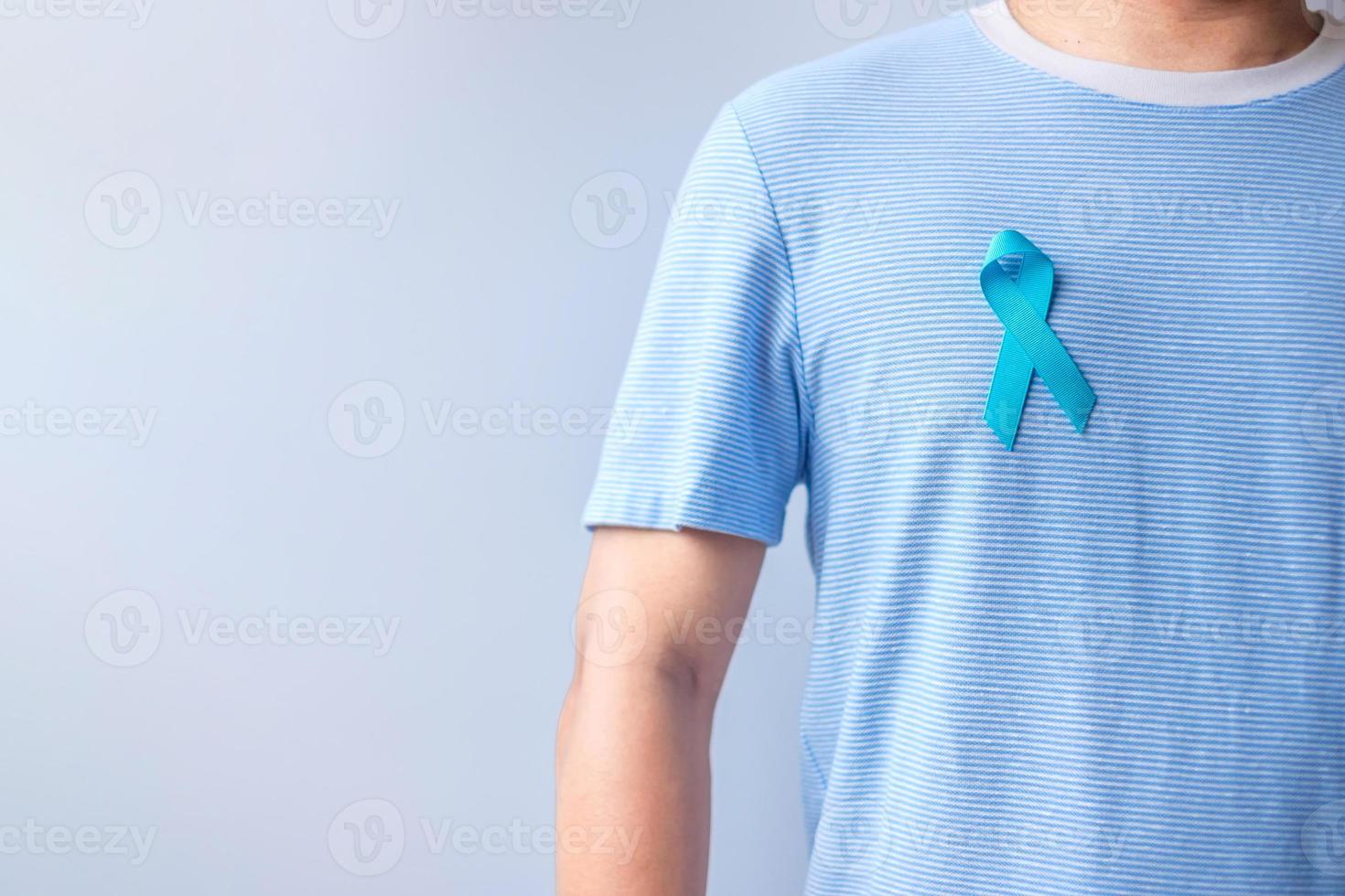 noviembre azul mes de concientización sobre el cáncer de próstata, hombre con camisa azul con la mano sosteniendo una cinta azul para apoyar la vida y la enfermedad de las personas. salud, dia internacional del hombre, padre, diabetes y dia mundial del cancer foto