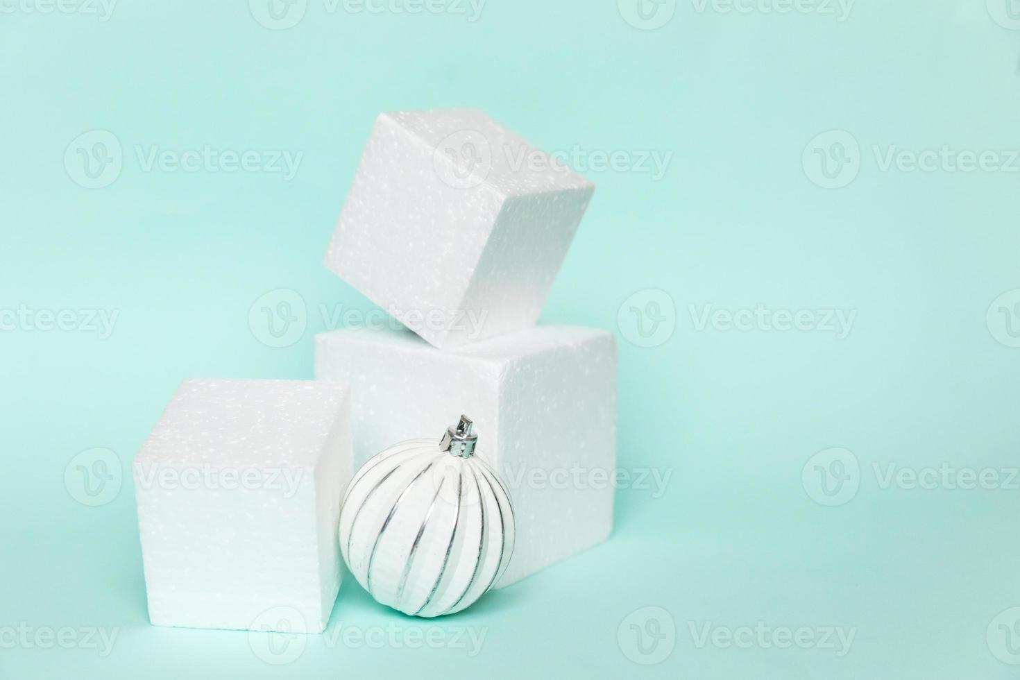 Simply minimal composition winter object ornament and cube shapes geometric form podium isolated blue pastel background. Christmas New Year december time for celebration concept. Mockup, copy space photo