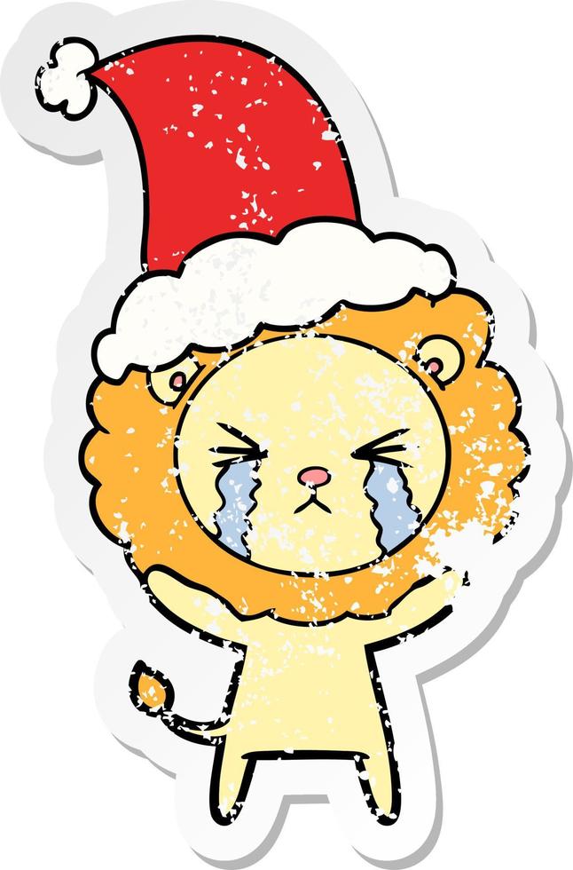 distressed sticker cartoon of a crying lion wearing santa hat vector