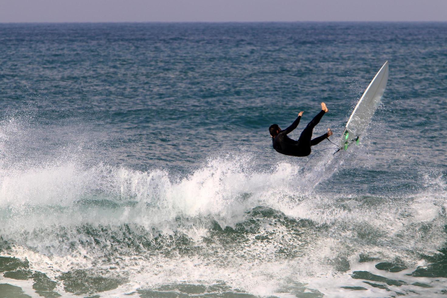 21 de diciembre de 2018 Israel. surfeando en olas altas en el mediterráneo. foto