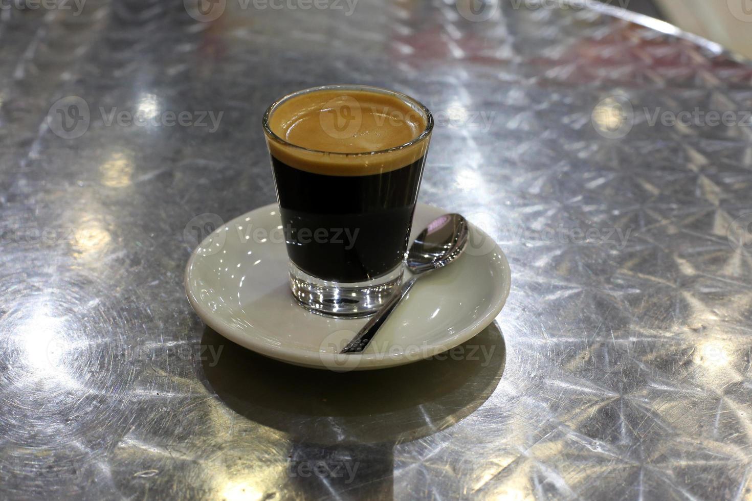 Hot and strong coffee is poured into a cup. photo