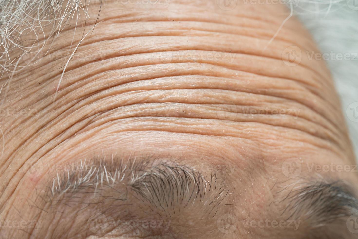 Asian elderly old woman face and eye with wrinkles, portrait closeup view. photo