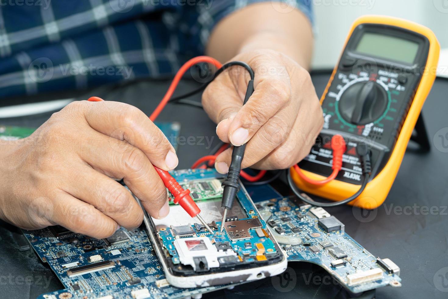 técnico que repara el interior del teléfono móvil con un soldador. circuito integrado. el concepto de datos, hardware, tecnología. foto