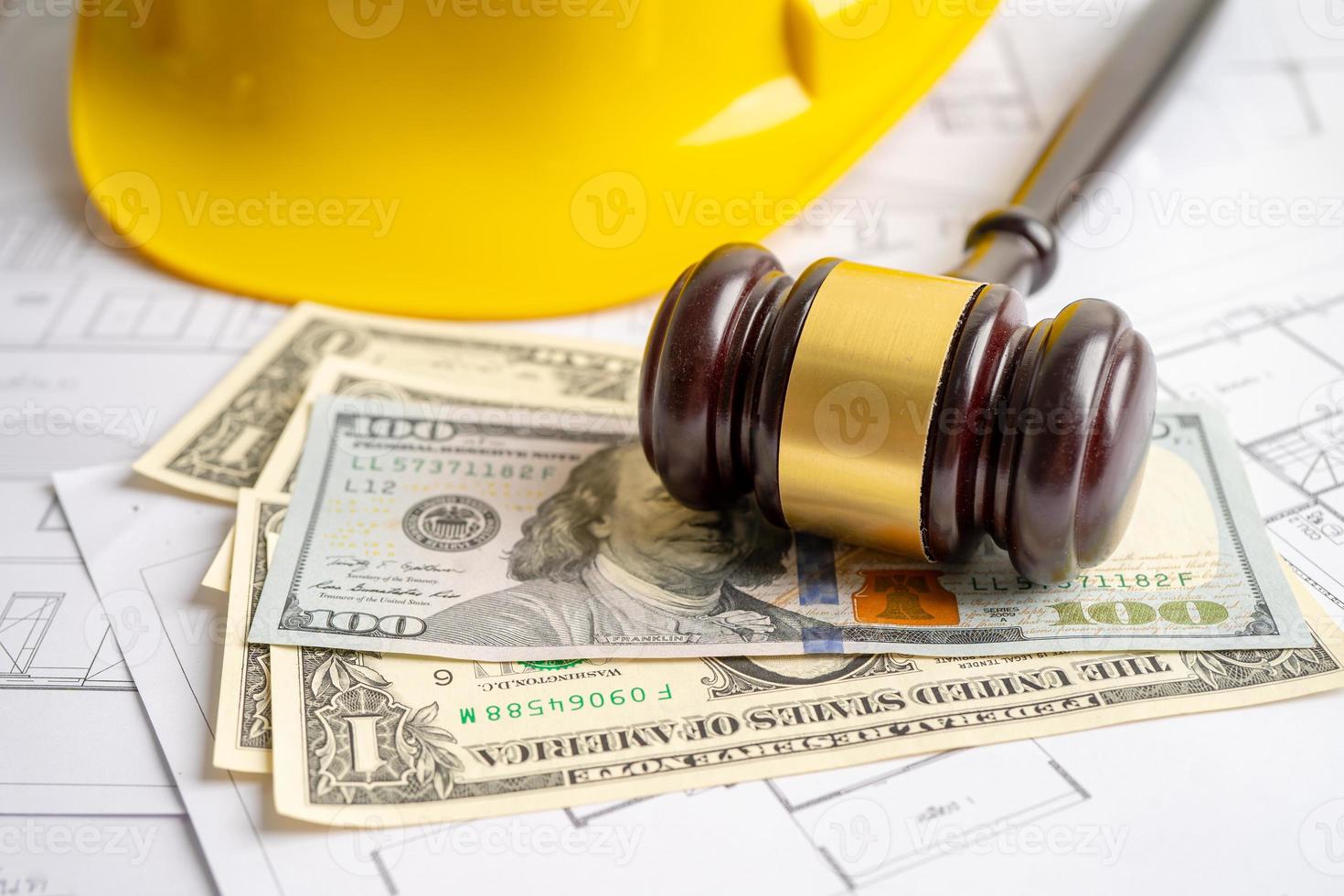 Architectural house plan project blueprint and Judge gavel hammer with yellow helmet and US dollar banknotes, Engineer and construction law and justice. photo