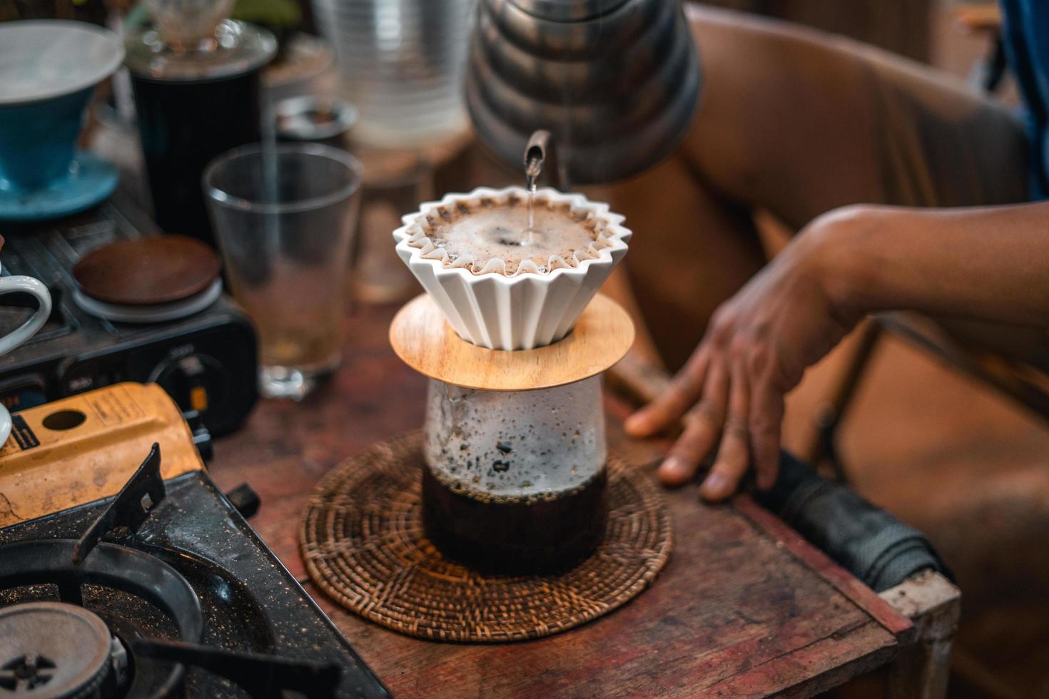 Drip coffee, barista pouring water on coffee ground with filter photo