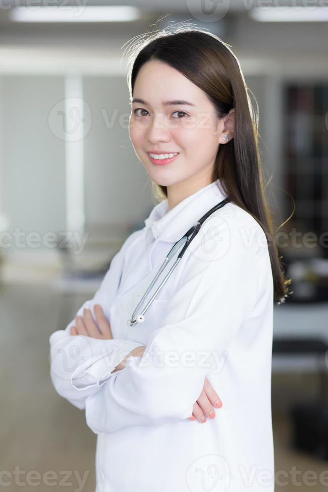 Asian woman doctor stands confidently and smiles. photo