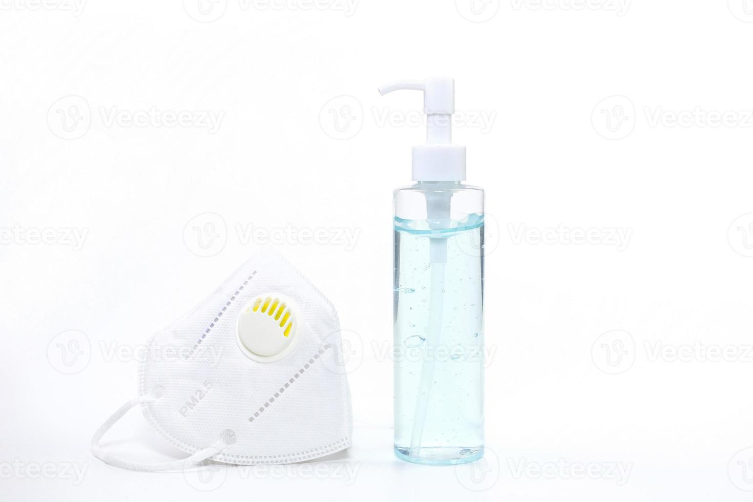 Alcohol gel and medical face mask on white background photo