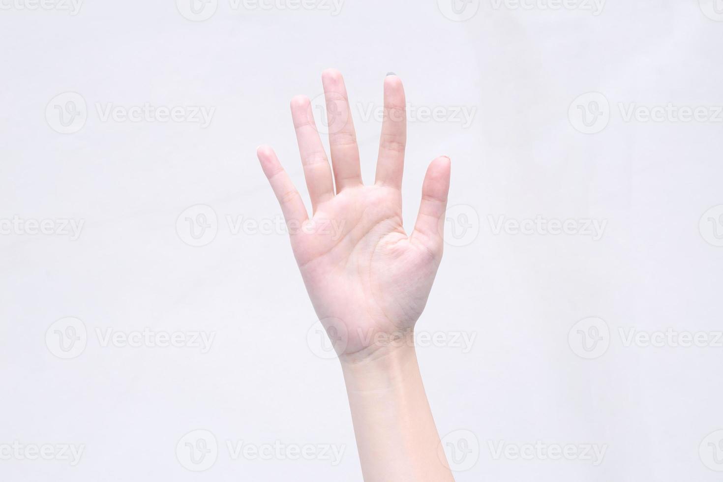 Young woman shows beautiful hand acted five fingers turned up on the isolated white background. photo