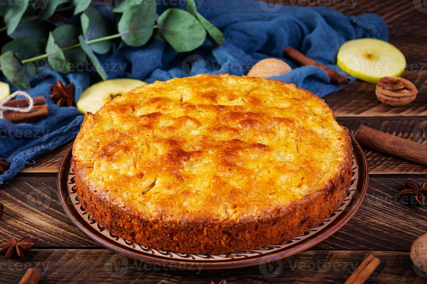 delicioso pastel de manzana casero sobre fondo de madera. tarta de manzana con ingredientes, manzanas y canela foto