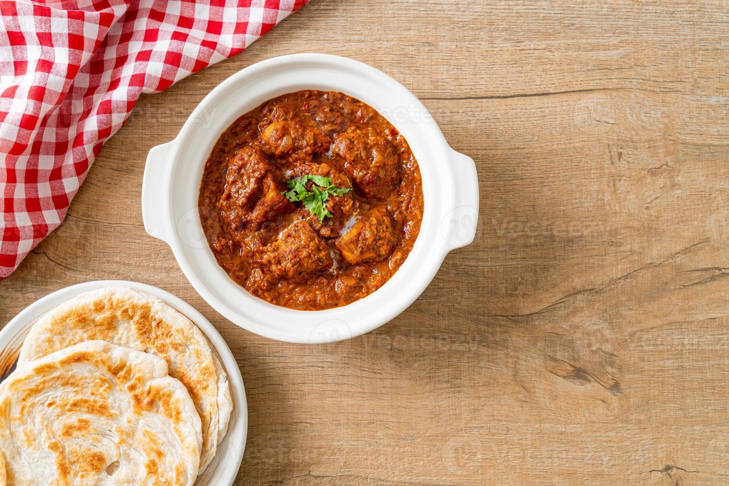 pollo tikka masala curry picante comida de carne con roti o pan naan foto