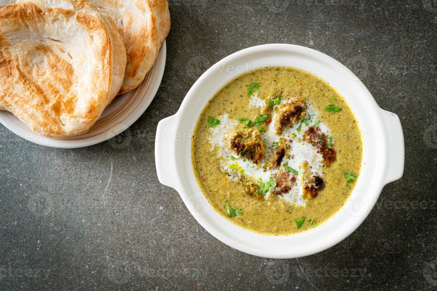 Afghani chicken in green masala curry or Hariyali tikka chicken hara masala with roti or naan bread photo