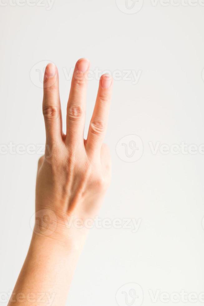 A hand showing three fingers for counting three. photo
