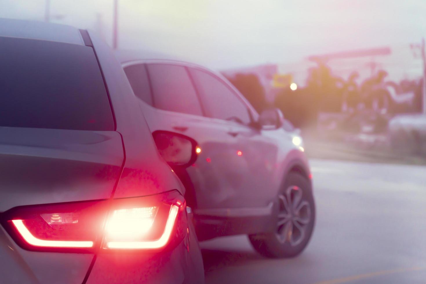 Abstract and blurred light brake of car in the U-Turn on the asphalt road. with other cars in the front prepare for U-Turn. With blurred of city and trees for background. Evironment everying time. photo