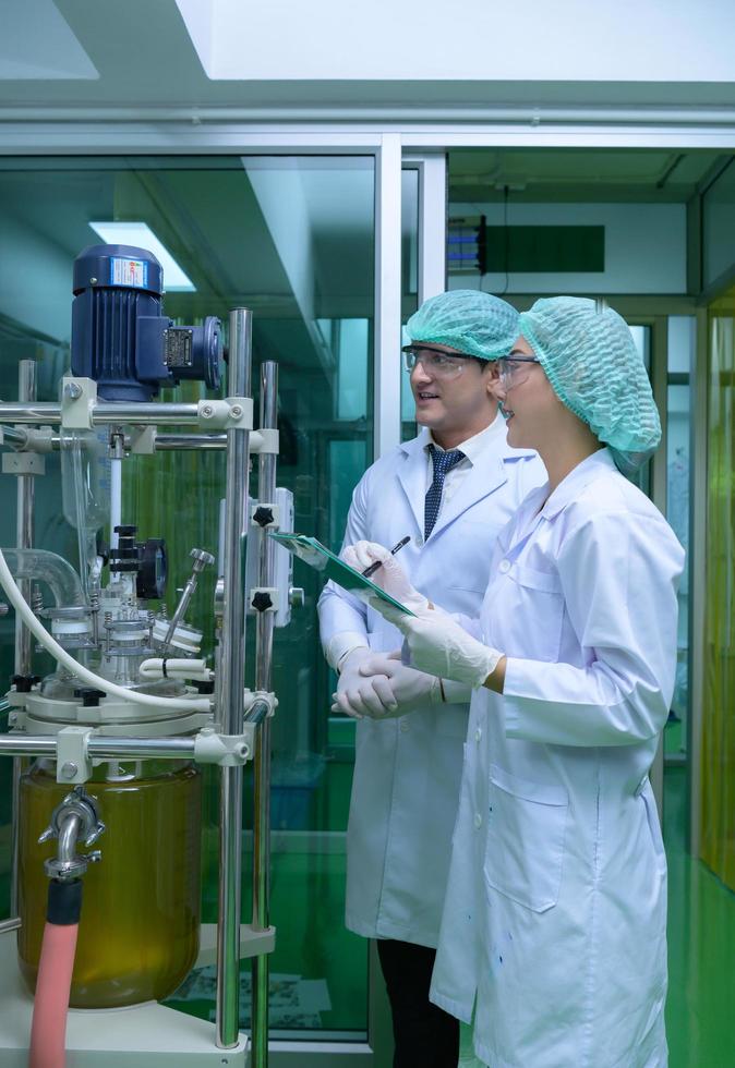 Scientists and assistants are in the machine room extracting oil and cannabis seeds. Inspecting cannabis oil extractor before starting to extract the prepared cannabis photo