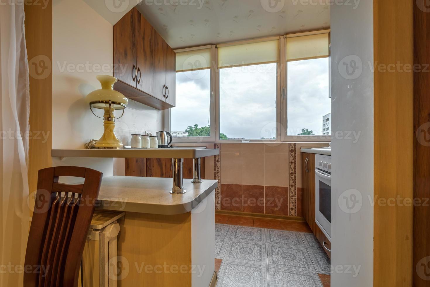 mesa servida en la sala de estar o cocina con tazas, platos, vasos y flores foto